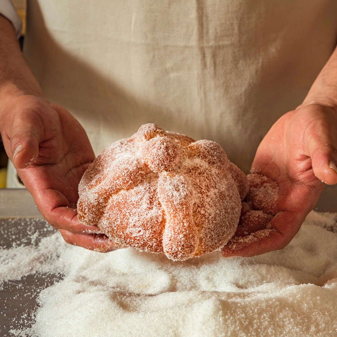 Image of Pan de Muerto in hands of the chef