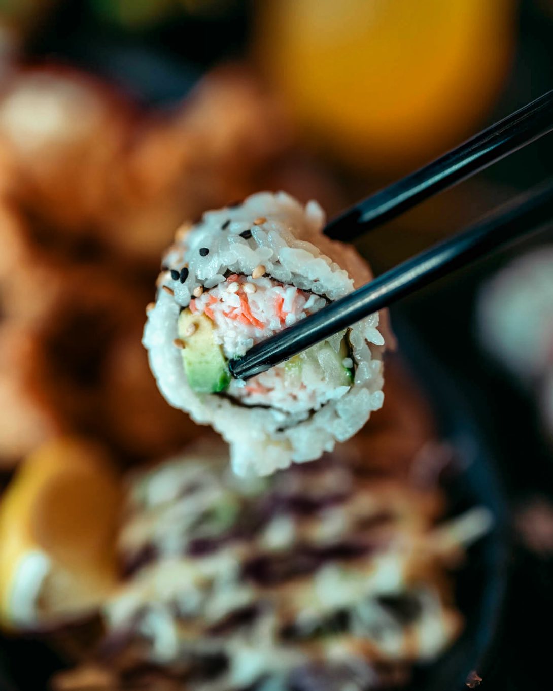 Image of California roll in chopsticks